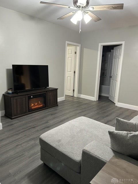 living room featuring dark hardwood / wood-style floors and ceiling fan