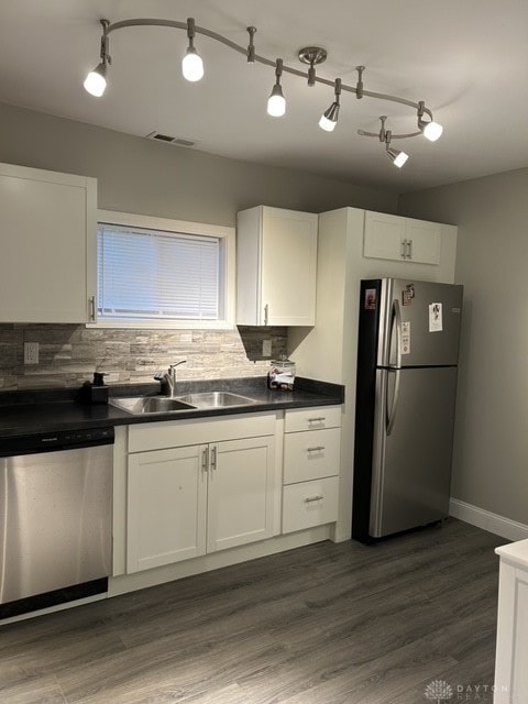 kitchen with appliances with stainless steel finishes, white cabinetry, sink, and dark hardwood / wood-style flooring