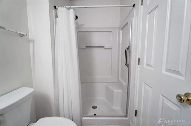 bathroom with curtained shower and toilet