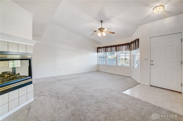 unfurnished living room featuring vaulted ceiling, light colored carpet, and ceiling fan