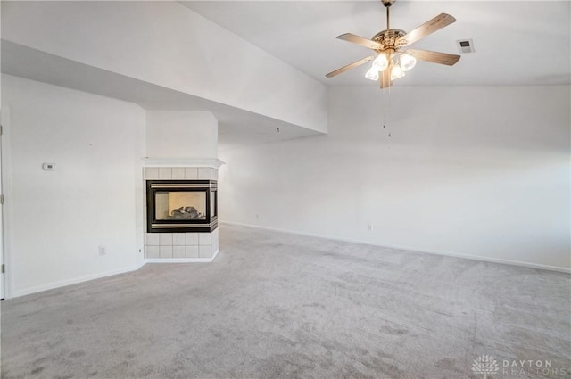 unfurnished living room featuring light carpet, vaulted ceiling, a fireplace, and ceiling fan