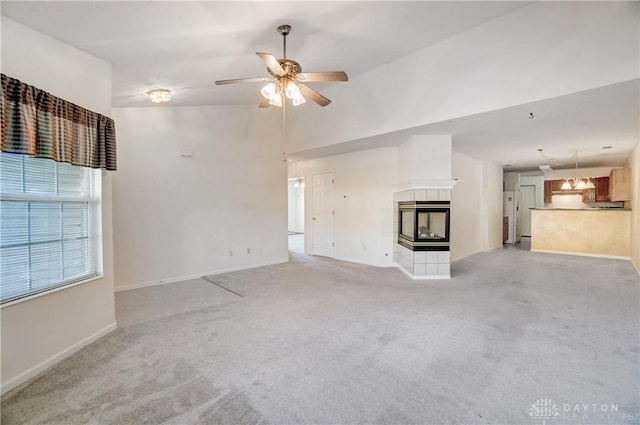 unfurnished living room with a multi sided fireplace, light colored carpet, lofted ceiling, and ceiling fan