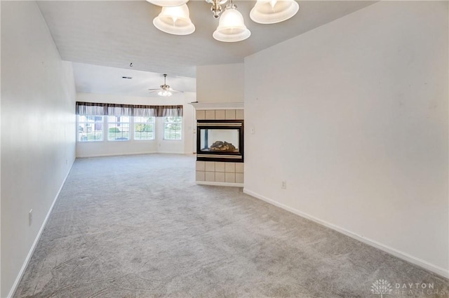 unfurnished living room featuring carpet floors, a tile fireplace, and ceiling fan