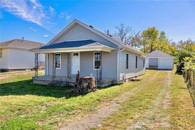 bungalow featuring a front yard, covered porch, an outdoor structure, and a garage