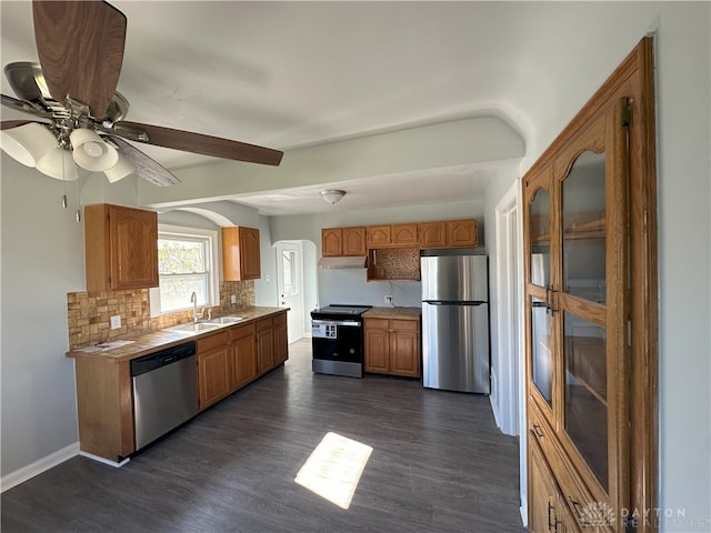 kitchen with decorative backsplash, appliances with stainless steel finishes, dark hardwood / wood-style flooring, and sink