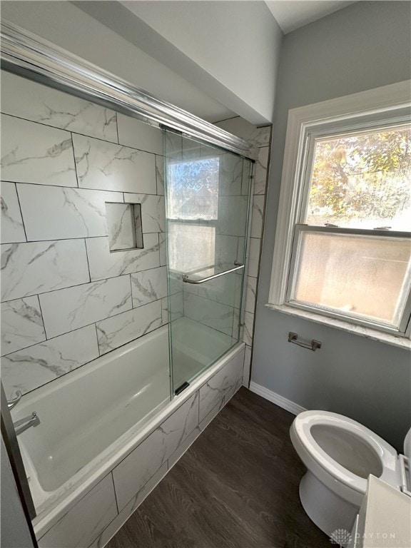 bathroom featuring shower / bath combination with glass door, toilet, and hardwood / wood-style flooring