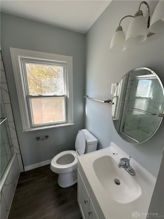 full bathroom with toilet, vanity, combined bath / shower with glass door, and hardwood / wood-style flooring