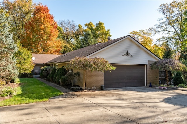 view of property exterior with a yard, concrete driveway, brick siding, and an attached garage