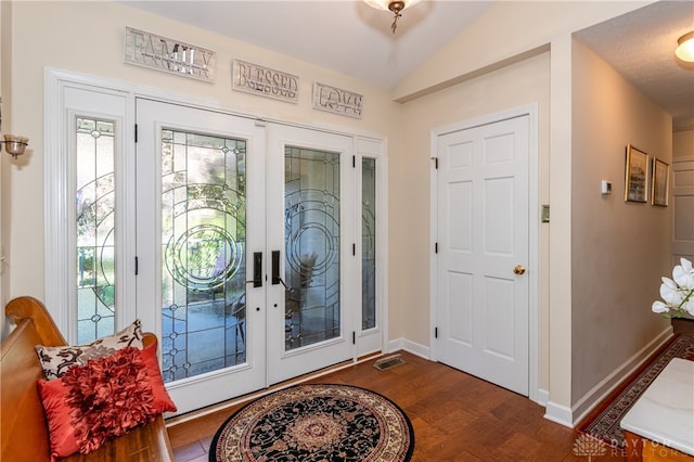 foyer entrance with french doors, dark wood-type flooring, and lofted ceiling