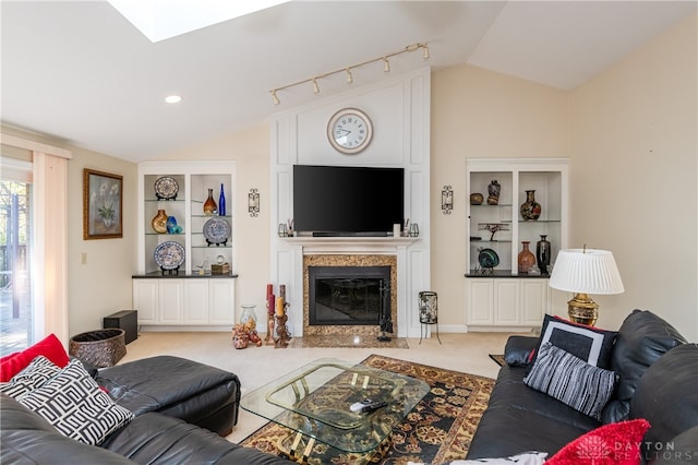 living room with light colored carpet, vaulted ceiling with skylight, and a fireplace