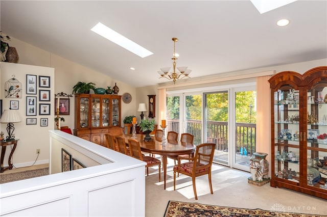 dining room featuring vaulted ceiling with skylight and a chandelier