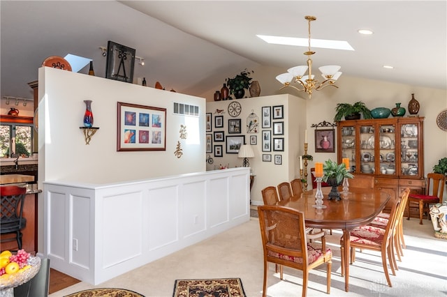 dining space featuring lofted ceiling with skylight and a chandelier