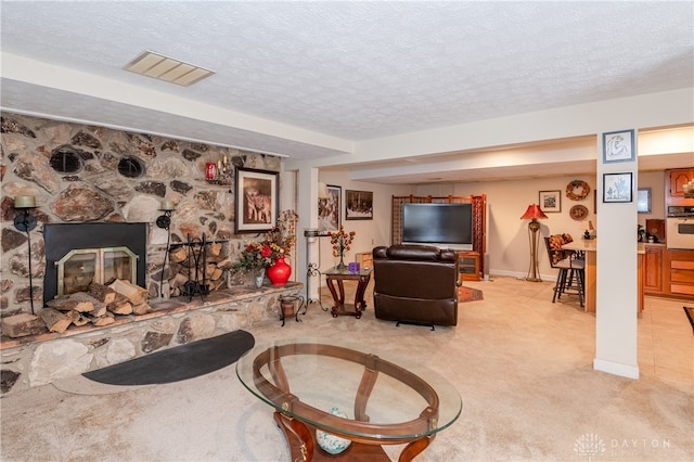 living room with light carpet, a textured ceiling, and a fireplace