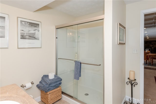 bathroom featuring vanity, a textured ceiling, and walk in shower