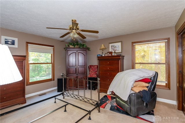 carpeted bedroom with a textured ceiling and ceiling fan