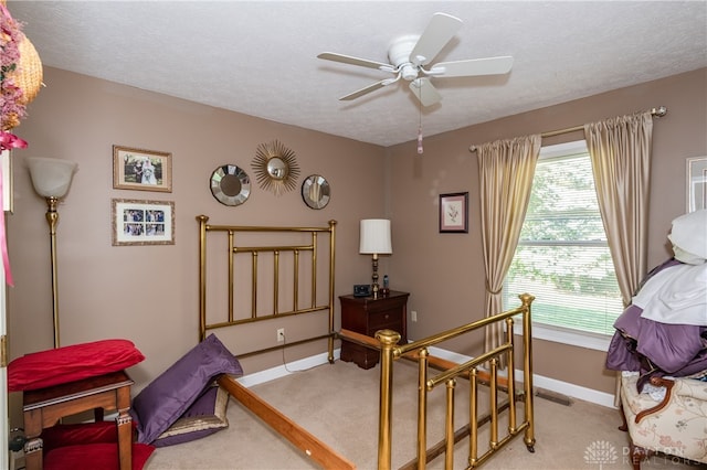 carpeted bedroom with a textured ceiling and ceiling fan