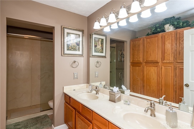 bathroom featuring toilet, a textured ceiling, walk in shower, and vanity