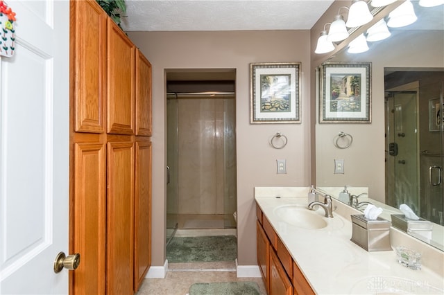 bathroom with vanity, a textured ceiling, and an enclosed shower