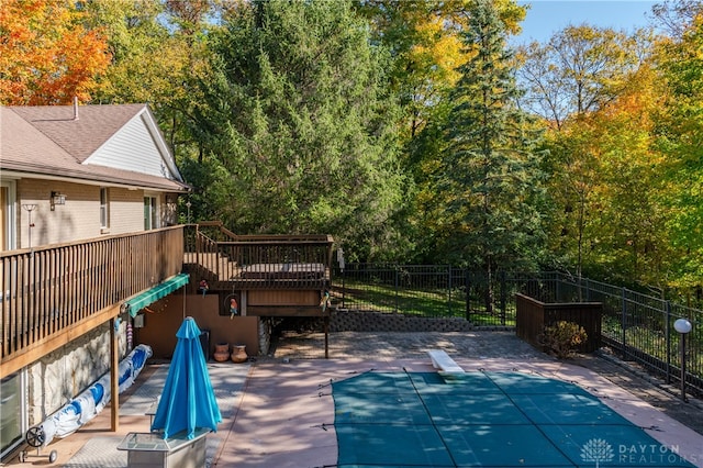 exterior space with a patio area, a wooden deck, and a diving board