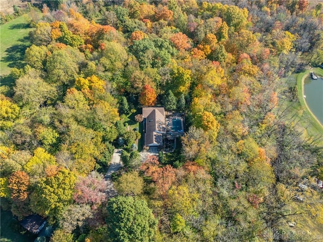 birds eye view of property with a water view and a wooded view