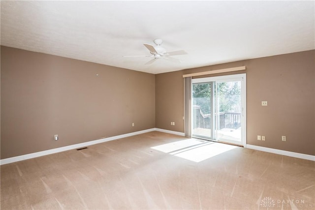 unfurnished room with a ceiling fan, light carpet, visible vents, and baseboards