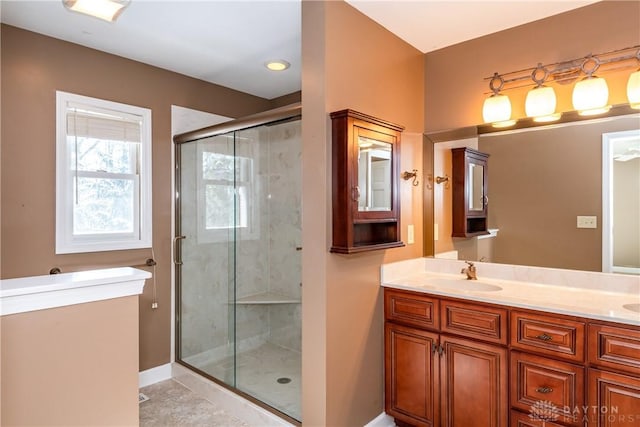 bathroom with a stall shower, a sink, baseboards, and double vanity