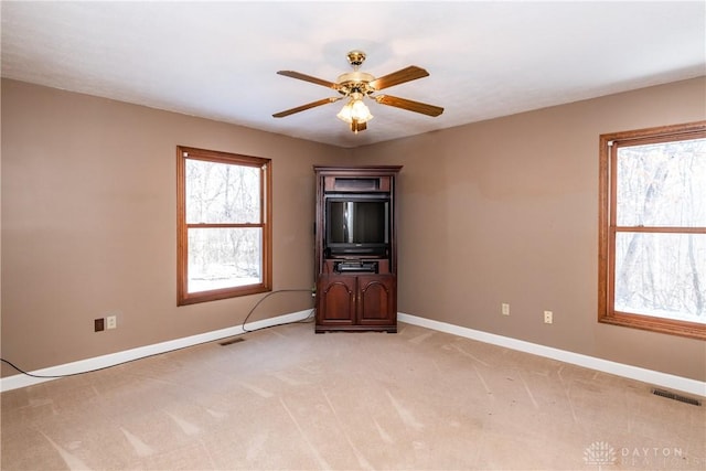 spare room featuring light carpet, baseboards, and visible vents