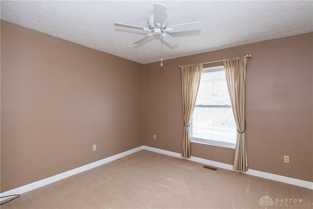 unfurnished room featuring light carpet, ceiling fan, visible vents, and baseboards