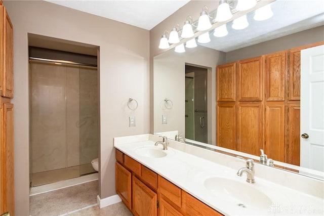 bathroom featuring double vanity, a closet, toilet, a sink, and walk in shower