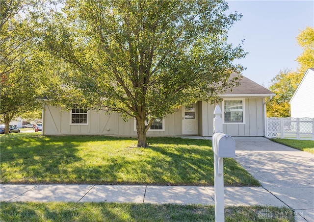 view of property hidden behind natural elements with a front yard