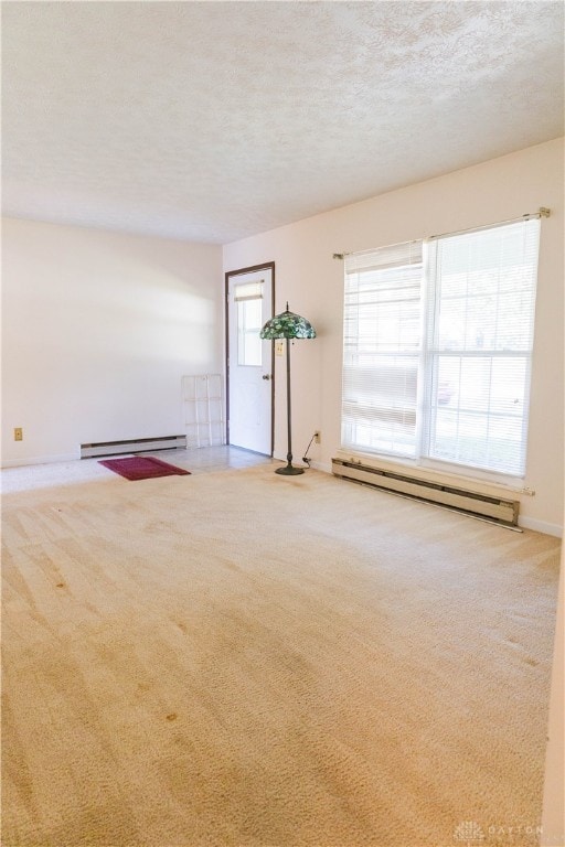 carpeted spare room featuring a textured ceiling and a baseboard radiator