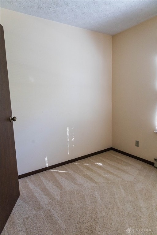 carpeted spare room with a textured ceiling