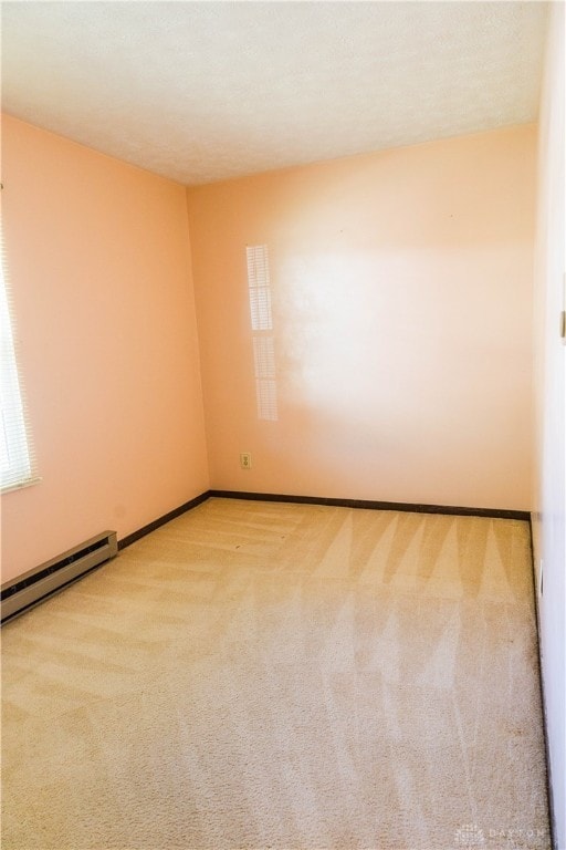 carpeted empty room featuring a baseboard radiator