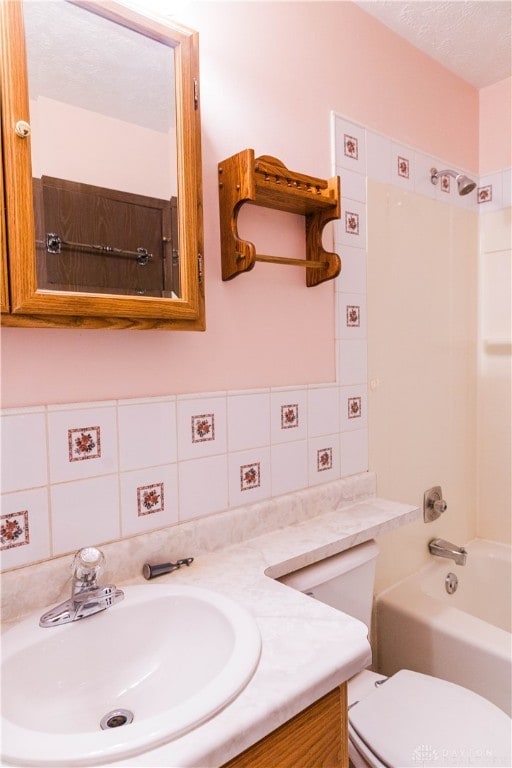 full bathroom featuring tasteful backsplash, a textured ceiling, toilet, vanity, and washtub / shower combination