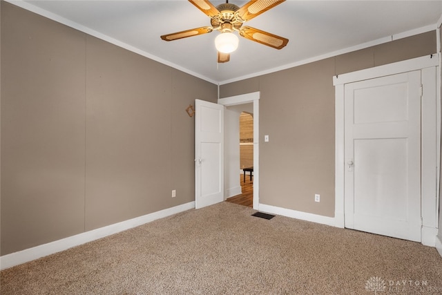 carpeted spare room featuring ornamental molding and ceiling fan