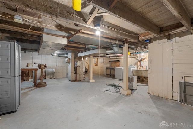 basement with washing machine and dryer and heating unit