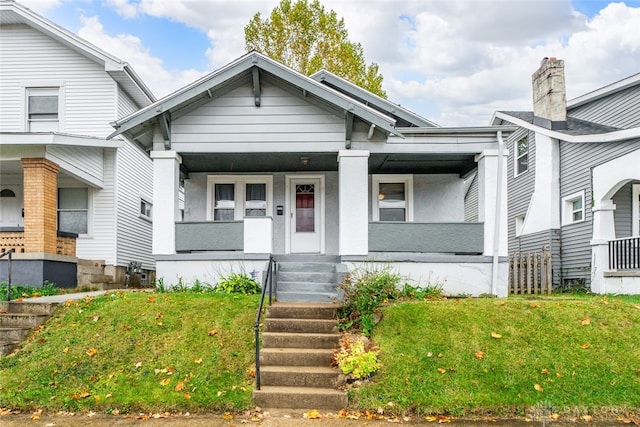 view of front of home with a porch and a front lawn