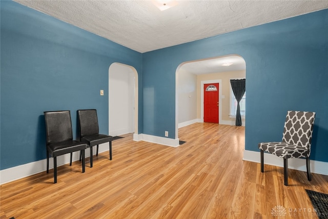 living area featuring a textured ceiling and light wood-type flooring