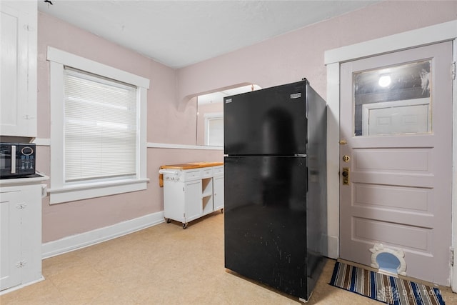 kitchen featuring white cabinetry and black appliances