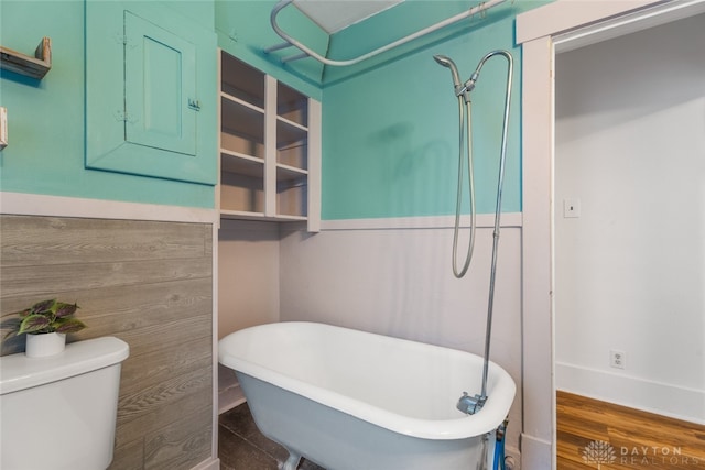 bathroom featuring toilet, a tub, and hardwood / wood-style flooring