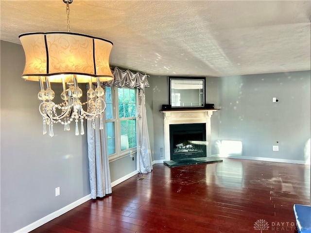 5 Devon Ct, Fairfield, OH 45014 - unfurnished living room featuring a chandelier, hardwood / wood-style floors, baseboards, a textured ceiling, and a fireplace with raised hearth