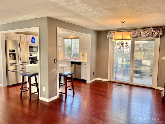 5 Devon Ct, Fairfield, OH 45014 - kitchen with stainless steel appliances, a textured ceiling, white cabinets, dark wood-type flooring, and a chandelier