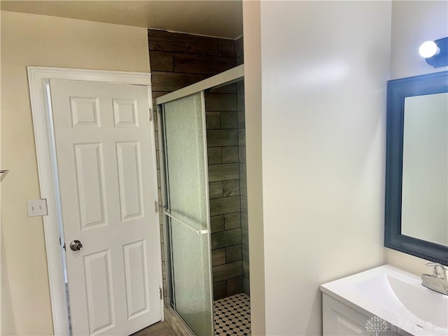 bathroom featuring a shower with door and vanity