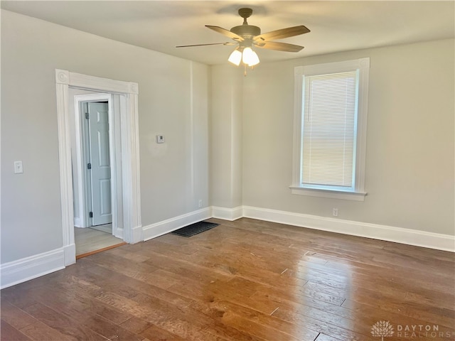 empty room with dark hardwood / wood-style floors and ceiling fan