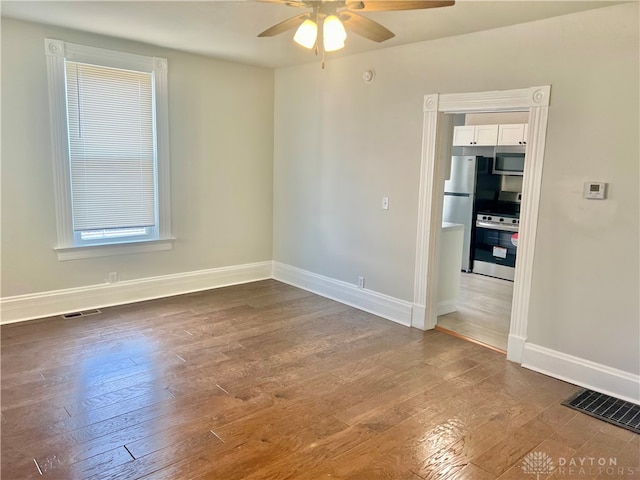 unfurnished room with dark wood-type flooring and ceiling fan