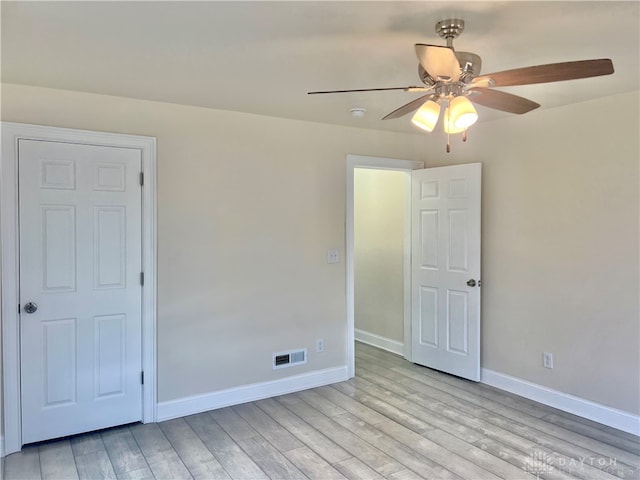 spare room with light wood-type flooring and ceiling fan