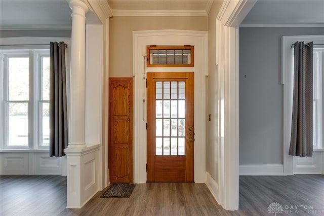 entryway with ornate columns, crown molding, and wood finished floors