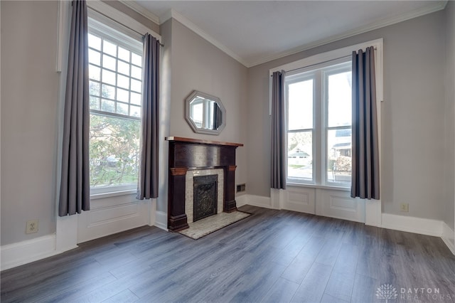 unfurnished living room featuring baseboards, a fireplace, ornamental molding, and wood finished floors