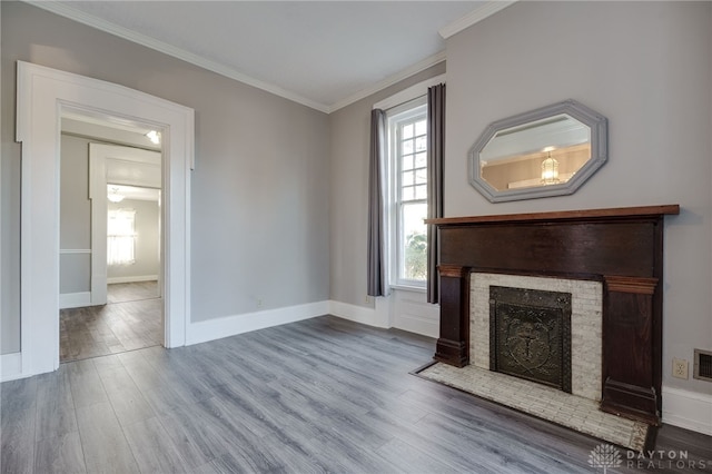 unfurnished living room featuring a fireplace with flush hearth, wood finished floors, baseboards, visible vents, and crown molding