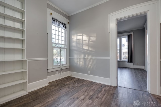 unfurnished room featuring dark wood-style floors, ornamental molding, and a wealth of natural light